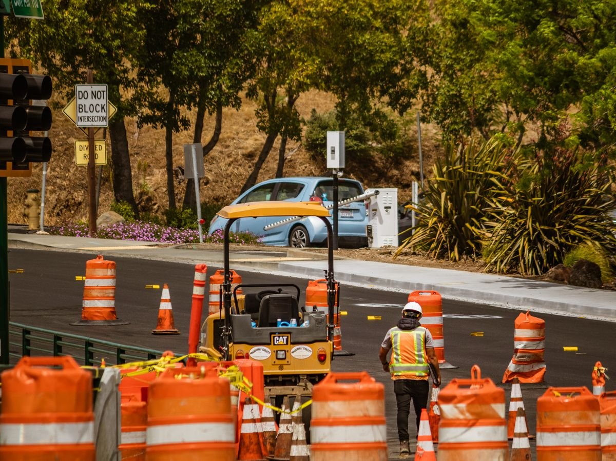 Road worker surrounded by traffic safety equipment